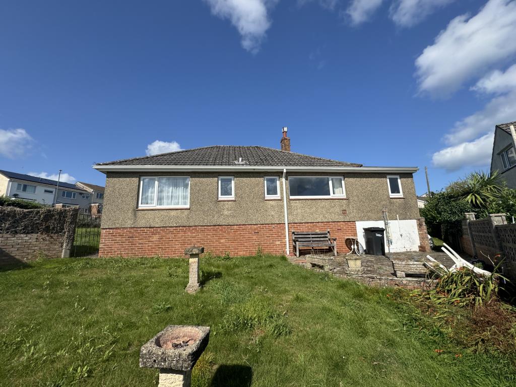 Lot: 131 - DETACHED BUNGALOW REQUIRING MODERNISATION ON A GENEROUS PLOT - Looking back at the house from the rear garden